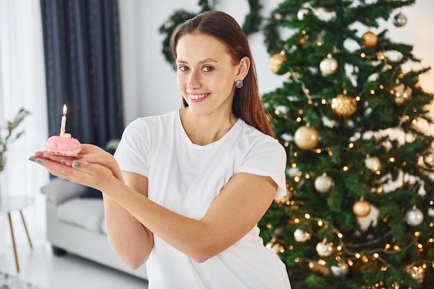 Humor de natal jovem em roupas casuais está dentro de casa na sala doméstica