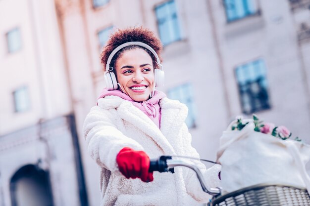 Humor lúdico. Morena fofa expressando positividade enquanto andava de bicicleta