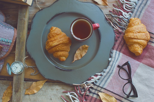 Humor de otoño composición de desayuno francés taza de té y cruasanes