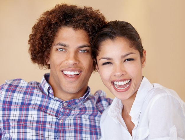 El humor y la risa de la pareja en el retrato de estudio, el amor y el vínculo en la relación sobre un fondo marrón, la lealtad y la comedia de las personas felices para el apoyo, la seguridad y la confianza en el matrimonio, el compromiso o el cuidado.