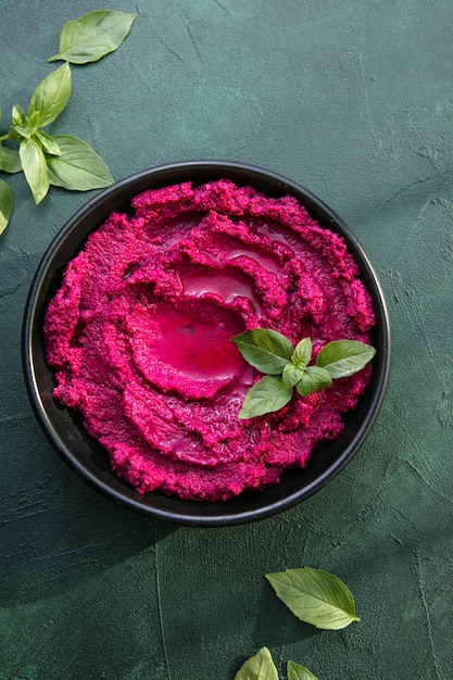 Humusschale. Rote-Bete-Hummus mit frischem Gemüse, Olivenöl auf dem Tisch