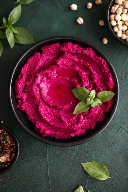 Humusschale. Rote-Bete-Hummus mit frischem Gemüse, Olivenöl auf dem Tisch