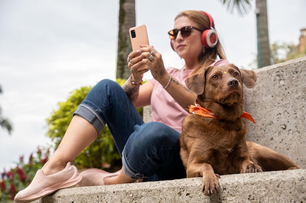 Foto hund und besitzer sitzen zusammen auf einer außenzementbank