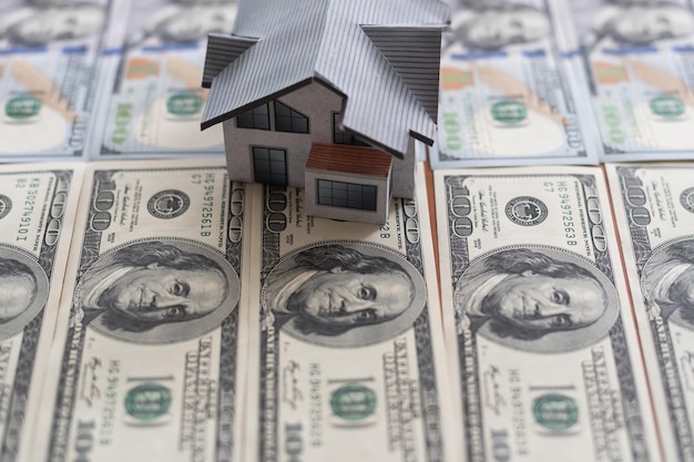 Hundert-Dollar-Scheine und ein Papierhaus, Immobilienverkauf beherbergt Konzeptgeschäft in einer Pandemie