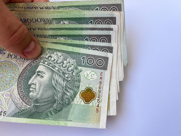 Hundert Zloty-Scheine Nahaufnahme in der Hand auf einem weißen, isolierten Hintergrund