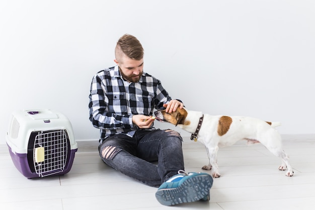 Hundetragetaschen und Haustierbesitzer-Konzept - Attraktiver fröhlicher Mann im karierten Hemd hält Favorit