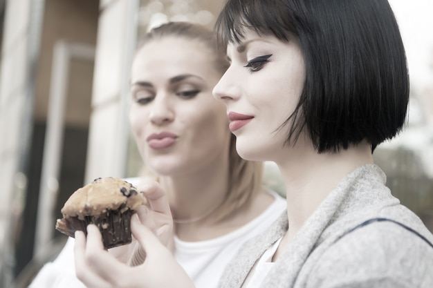 Hunger Versuchung Appetit Konzept Frauen betrachten Cupcake in Paris Frankreich Freundinnen