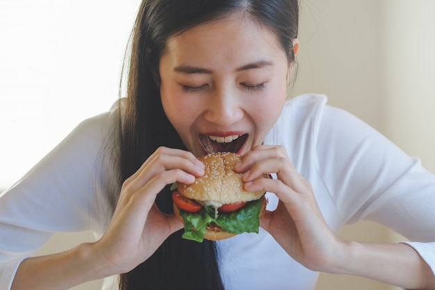 Foto hungrige asiatische frau essen burger