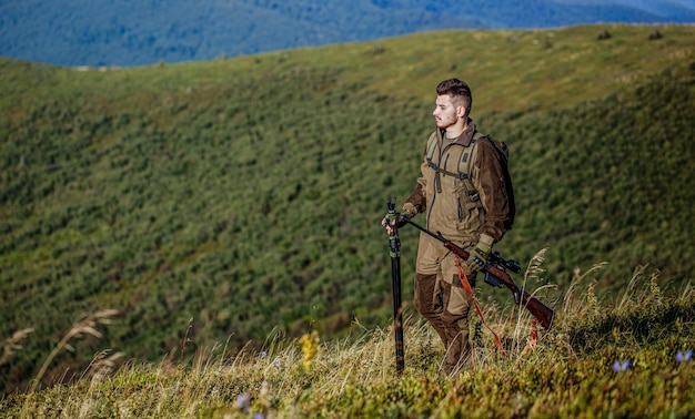 Hunter com arma de caça e forma de caça para caçar. Hunter está mirando. O homem está caçando. Rifle de caça de caça. Homem caçador. Período de caça. Homem com uma arma.