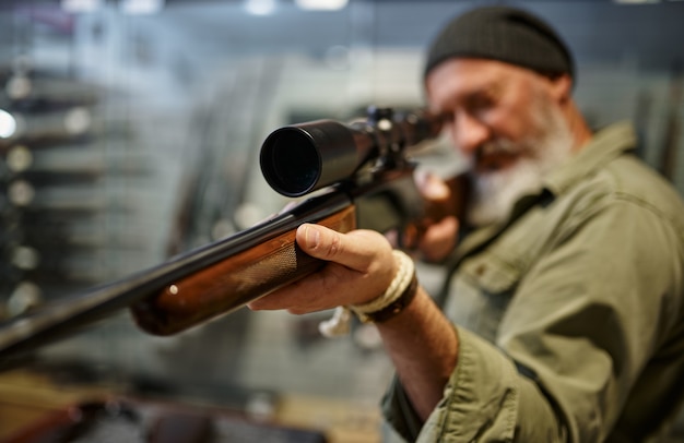 Hunter comprando rifle com mira óptica, loja de armas