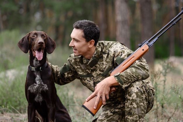 Hunter Pets Good Dog Homem com Rifle na floresta.