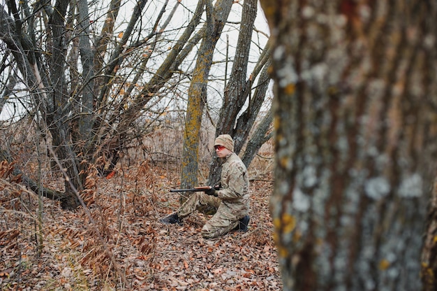 Hunter uniformizado com rifle de caça