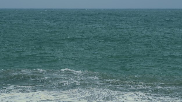 Foto el huracán esparce el océano grandes olas de viento hermosas olas verdes azules salpicando