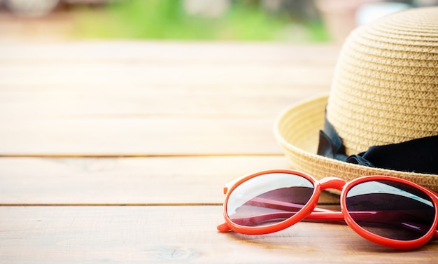 Foto hut und rote sonnenbrille gestalten auf dem holz