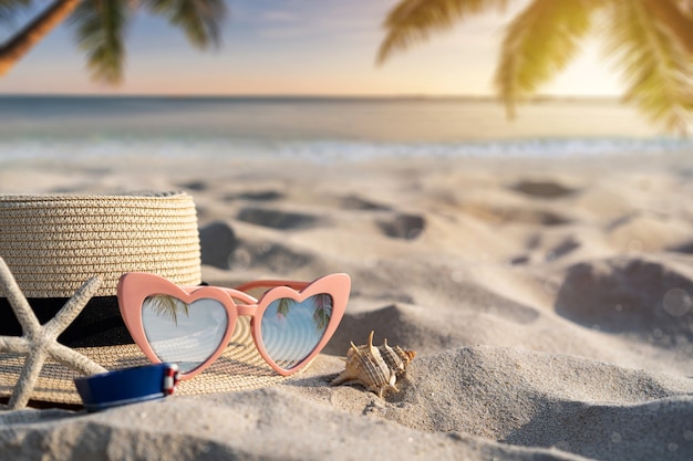 Hut und Sonnenbrille am tropischen Sandstrand mit Kopienraum, Sommerferienkonzept