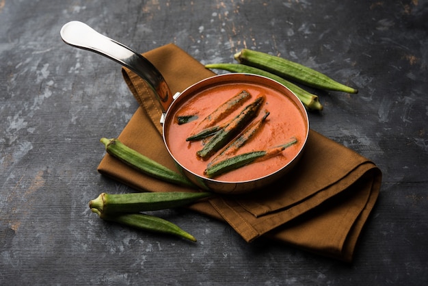 Hyderabadi Bhindi ka Salan u Okra salan elaborado con dedos de mujer o ocro. Receta de plato principal de la India. servido en un bol. enfoque selectivo