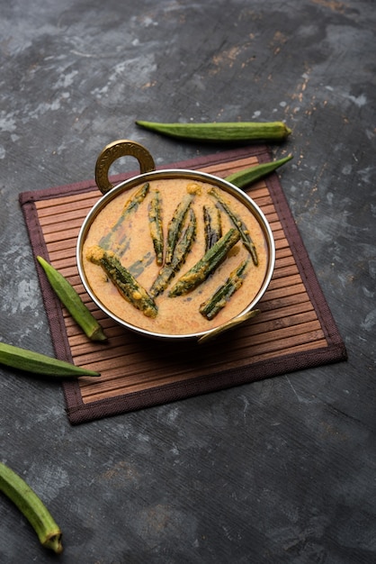 Hyderabadi Bhindi ka Salan u Okra salan elaborado con dedos de mujer o ocro. Receta de plato principal de la India. servido en un bol. enfoque selectivo