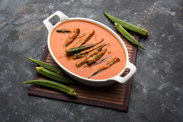 Hyderabadi Bhindi ka Salan u Okra salan elaborado con dedos de mujer o ocro. Receta de plato principal de la India. servido en un bol. enfoque selectivo