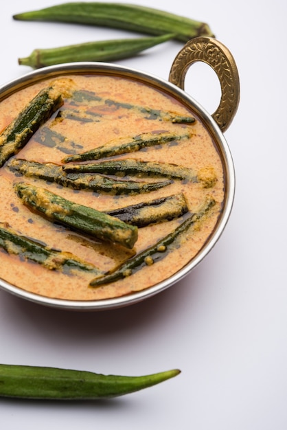 Hyderabadi Bhindi ka Salan u Okra salan elaborado con dedos de mujer o ocro. Receta de plato principal de la India. servido en un bol. enfoque selectivo