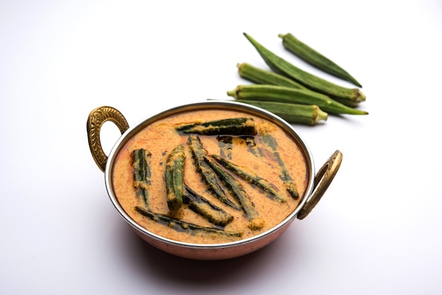 Hyderabadi Bhindi ka Salan u Okra salan elaborado con dedos de mujer o ocro. Receta de plato principal de la India. servido en un bol. enfoque selectivo