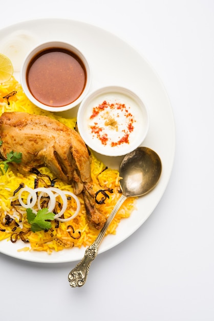 Hyderabadi-Hühnchen oder Dum Biryani, serviert in einem Kadhai oder einer Schüssel mit Joghurt-Dip. selektiver Fokus