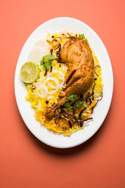 Hyderabadi-Hühnchen oder Dum Biryani, serviert in einem Kadhai oder einer Schüssel mit Joghurt-Dip. selektiver Fokus