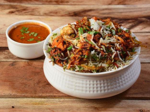 Hyderabadi tradicional Verduras vegetales dum biryani con verduras mixtas servidas con enfoque selectivo de curry