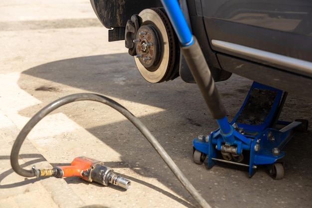 Hydraulischer Wagenheber hebt das neue Auto an, um den Reifen zu wechseln