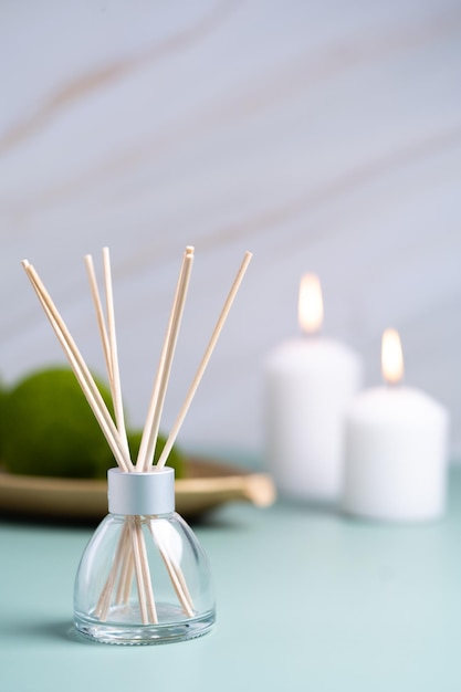 Hygge- und Aromatherapie-Konzeptkerzen und Aromadiffusor auf dem Tisch zu Hause