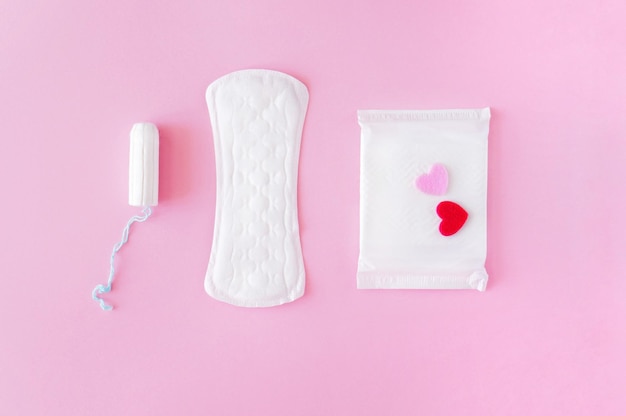 Hygienetupfer und Pads auf rosafarbenem Hintergrund Eine alternative Auswahl an Damenhygieneprodukten