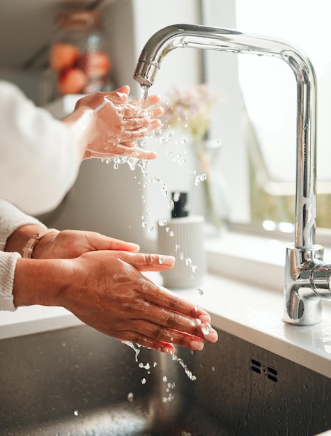 Hygienewasser und Händewaschen in einem Küchenbecken für eine gesunde Reinigung und Frische vor dem Kochen. Morgendliche Nachhaltigkeit und eine Person mit Flüssigkeit für Reinheit und Routine der häuslichen Hygiene in einem Waschbecken