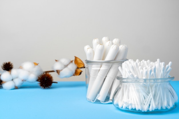 Hygienische Tampons und Baumwollohrknospen auf Papierhintergrund