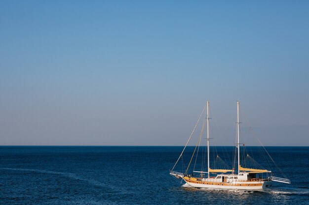 Iate à vela branco de dois mastros no fundo do mar azul