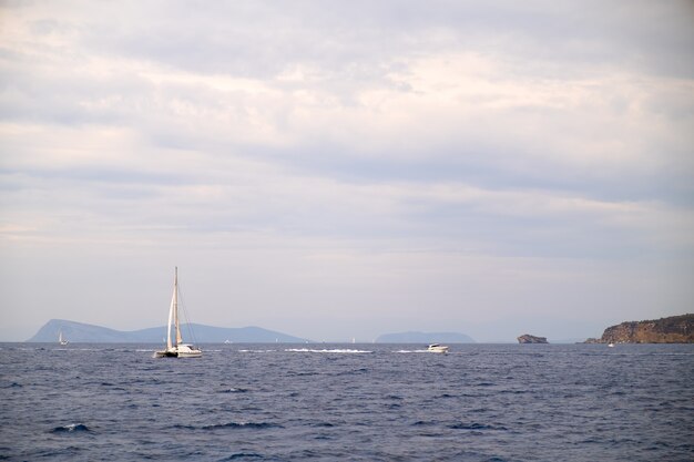 Iate a vela catamarã ancorado em águas do mar de um azul profundo