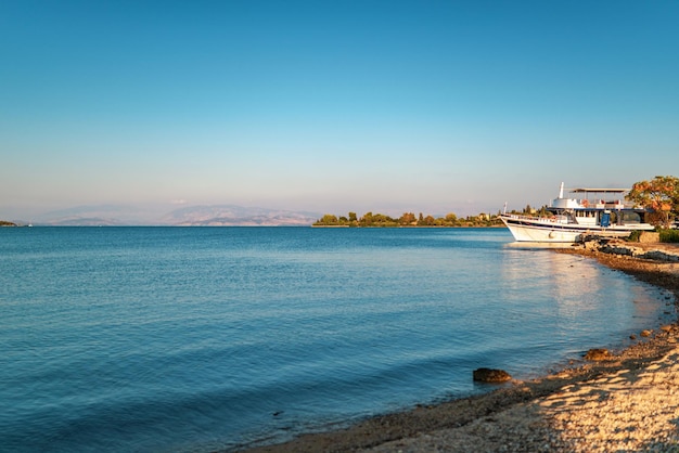 Iate ancorado à beira-mar perto da ilha de Corfu ao pôr do sol