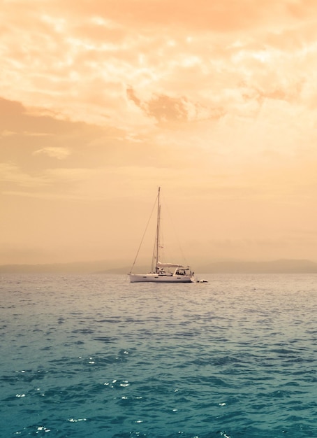 Iate ao pôr do sol na ilha no mar Mediterrâneo na Grécia