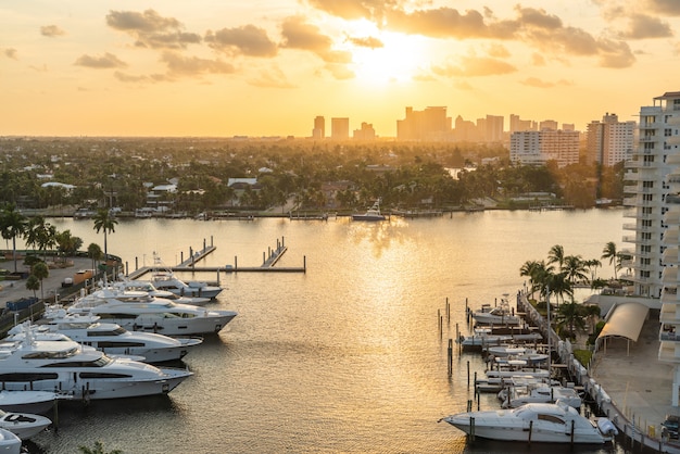 Iate de luxo estacionado em um canal com o sol caindo em Fort Lauderdale. Porto de Fort Lauderdale com pôr do sol na área da marina