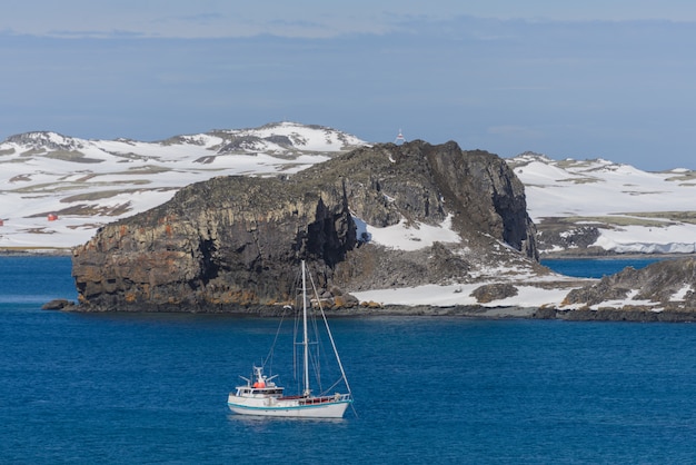 Iate de vela e iceberg no mar antártico