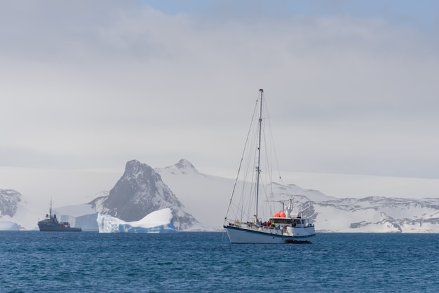 Iate de vela e iceberg no mar antártico