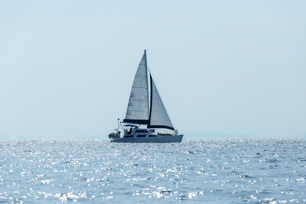 Iate luxuoso do navio de navigação com as velas brancas no mar.