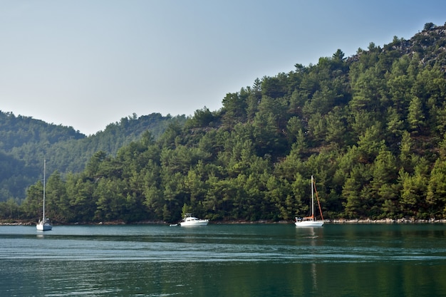 Iate navega no mar ao longo das montanhas