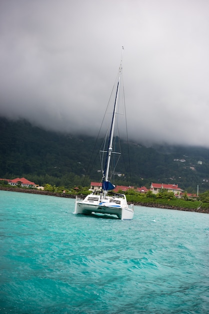 Iate recreativo no nevoeiro na costa das Seychelles. Tiro vertical