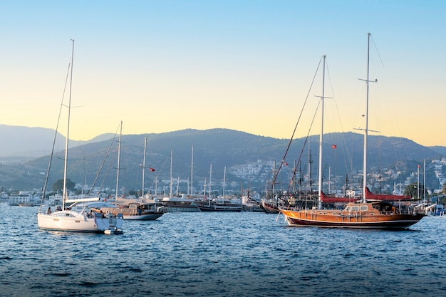 Iates de luxo ancorados na marina ao pôr do sol.