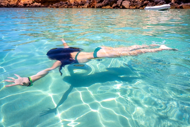 Ibiza-Bikinimädchen, das klaren Wasserstrand schwimmt