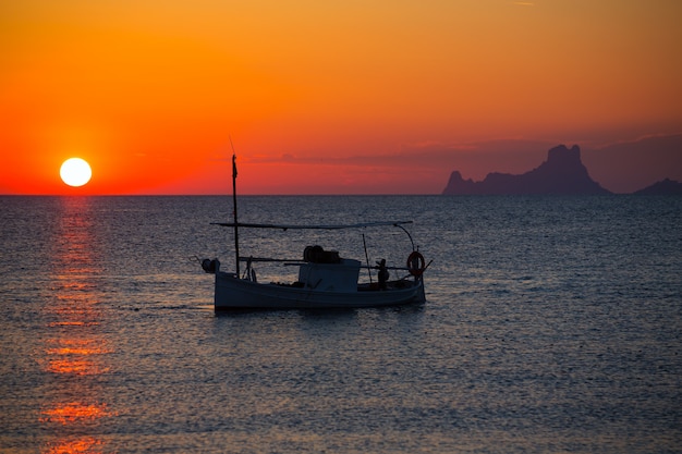 Ibiza-Sonnenuntergang Es Vedra-Ansicht und Fischerboot Formentera