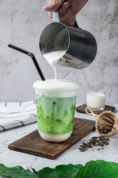 Iced Milk Green Tea oder Thai Milk Tea im Glas auf dem Tisch