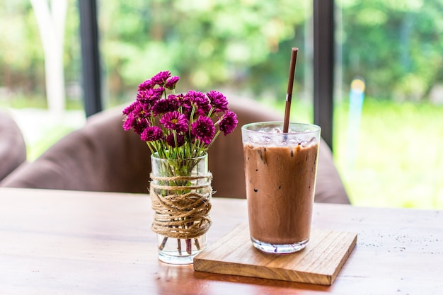 Iced Schokolade und lila Blumen in einer Vase.