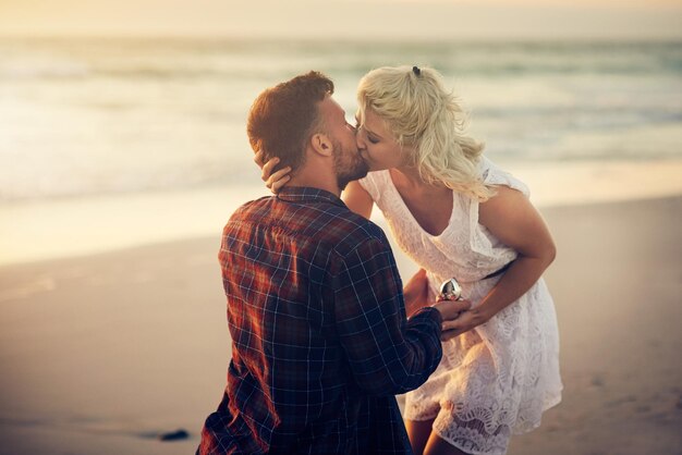 Ich bin bereit, mein Leben mit dir zu beginnen Aufnahme eines jungen Mannes, der seiner Freundin am Strand einen Heiratsantrag macht