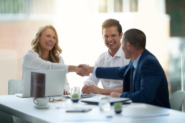 Ich bin mir sicher, dass Sie in unserem Unternehmen etwas bewegen werden Aufnahme von Geschäftsleuten, die sich während eines Meetings in einem Büro die Hände schütteln