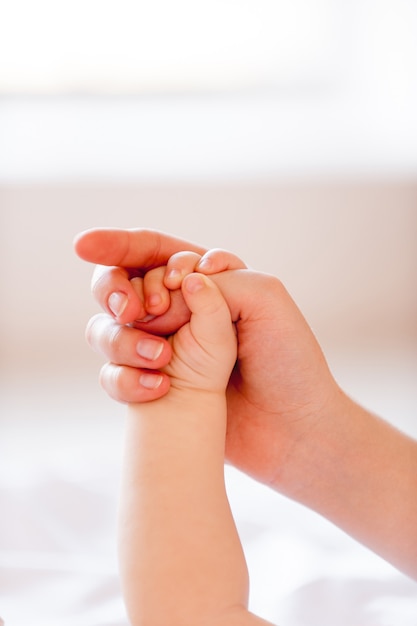 Ich brauche deine Fürsorge! Nahaufnahme von Baby mit Mutterfinger